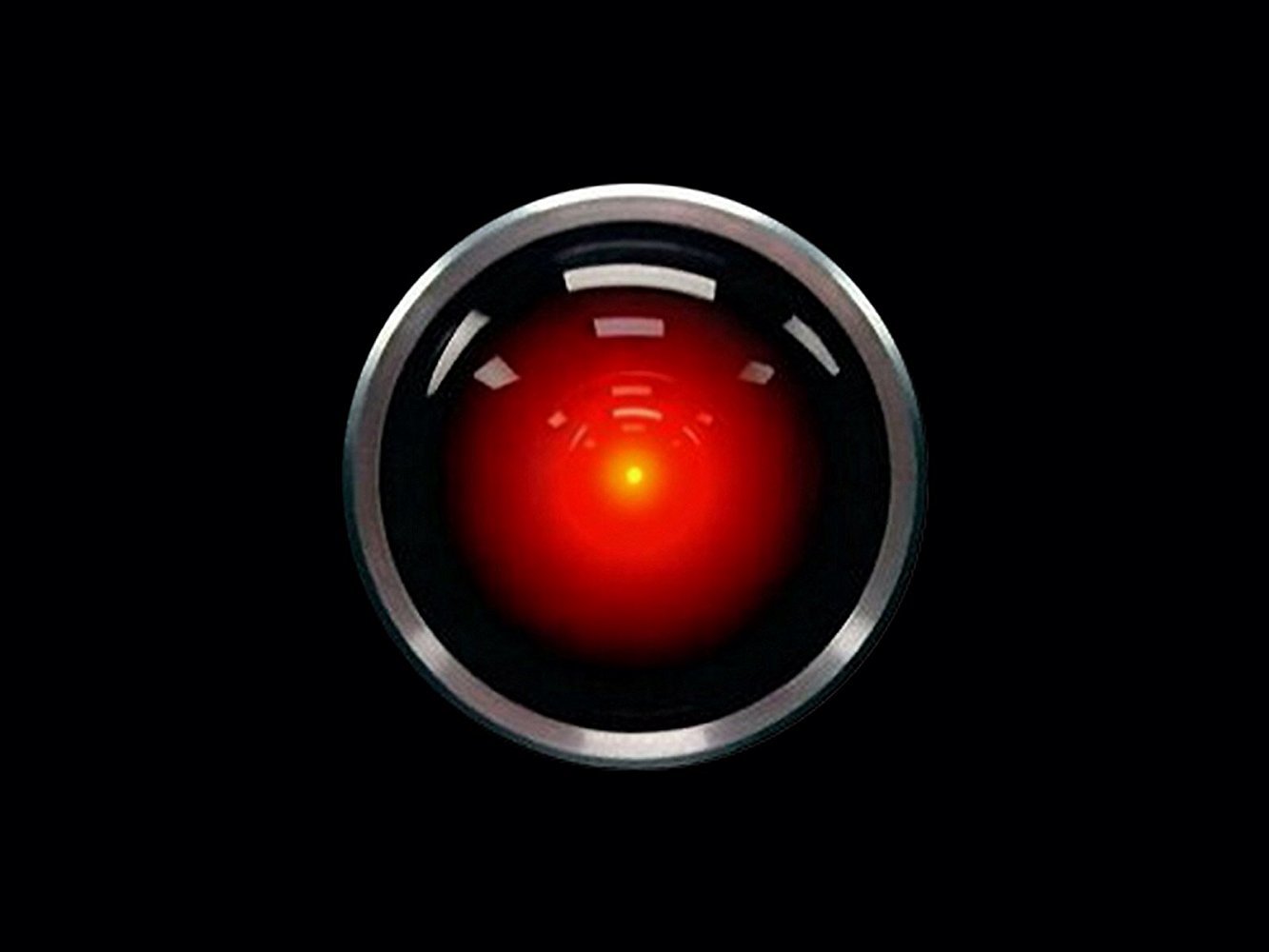 A circular red light surrounded by a metallic frame on a black background, resembling an artificial intelligence interface.